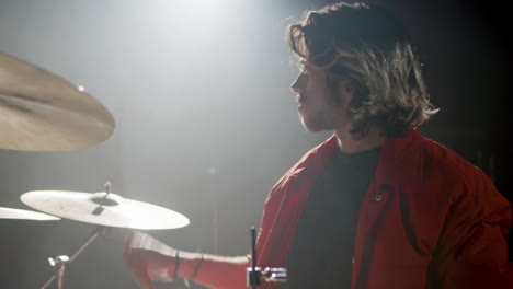 young male drummer playing drums at music studio