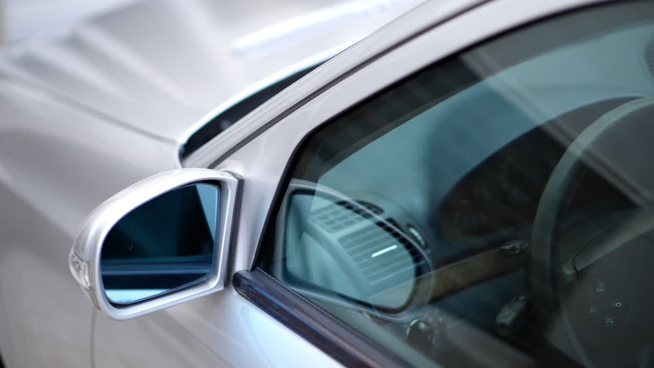 Close up of the mirror and the front window of a silver car