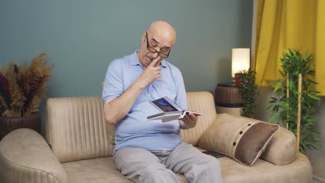 Old-man-looking-at-family-album-with-trembling-hand.