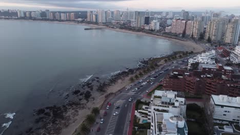 Aerial-flyover-traffic-on-coastal-road-in-Punta-del-Este-during-sunset