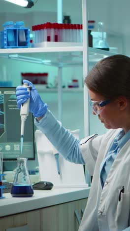 vertical video: scientist woman pipetting liquid to test tube