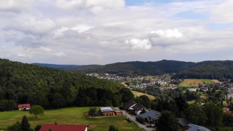 Aerial-forward-flight-through-German-local-town-on-sunny-and-cloudy-day,-Germany