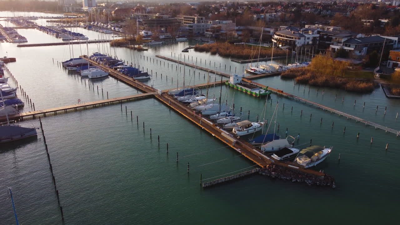 Drone view of Balatonfured marina with turquoise water and boats docked at golden hour