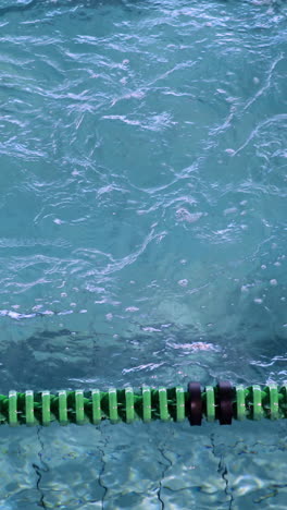 vertical video of fit woman doing the breast stroke in swimming pool in the leisure center