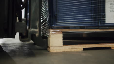 a forklift carrying a palet of boxes that contain finished car metal parts ready for delivery to assembly factories