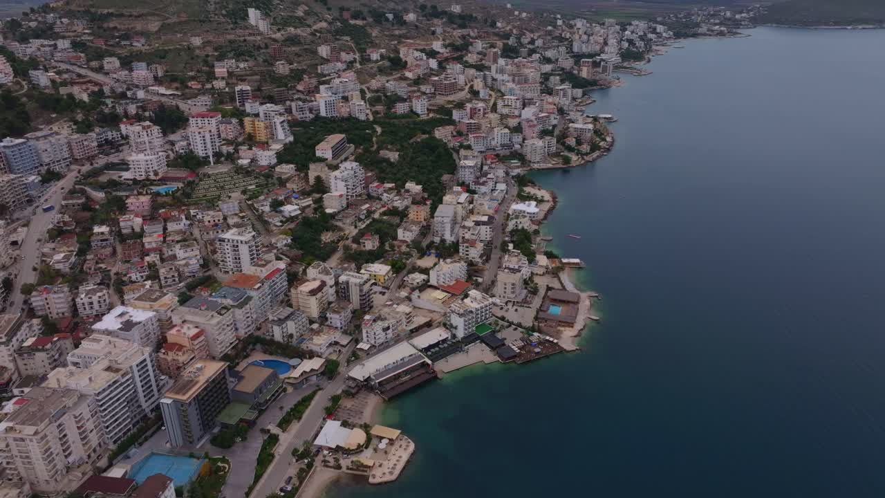 Manzaralı tepelerle çevrili Saranda'nın sahil şehrinin havadan görünümü.