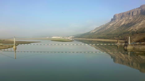 Toma-Aérea-Hacia-Atrás-Del-Puente-En-El-Embalse-De-Studen-Kaldenets-Durante-El-Día-Soleado