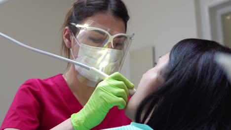 mujer en el higienista dental recibiendo blanqueamiento dental profesional y limpieza por ultrasonido. filmado en 4k