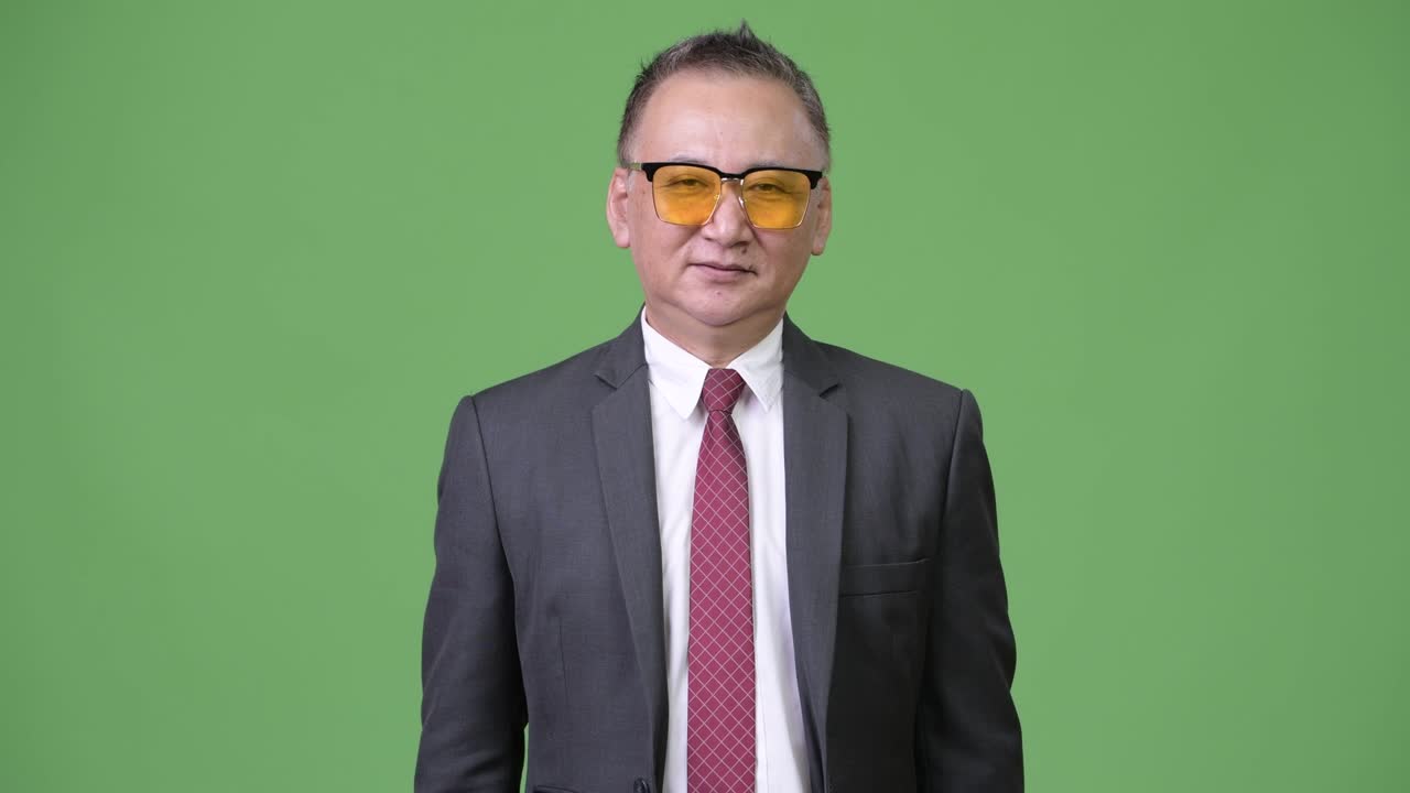 초록색 바탕에 선글라스를 입은 성숙한 일본인 사업가