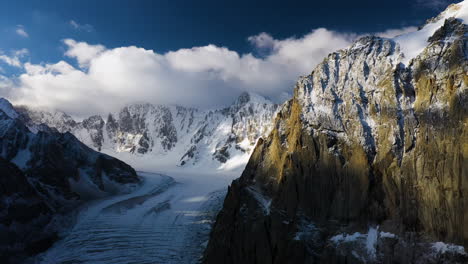 epische filmische luftdrohnenaufnahme einer großen passage und eines berges auf dem ak-sai-gletscher während des sonnenuntergangs in kirgisistan