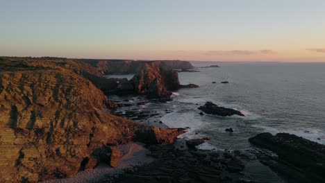 red sandstone sea cliffs at the rocky shore of algarve, portugal