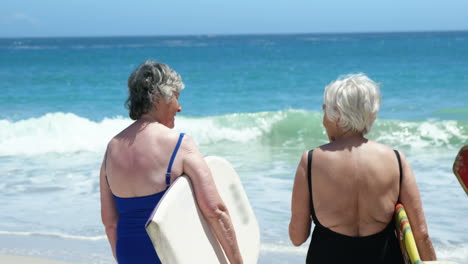 senior woman holding surfboard