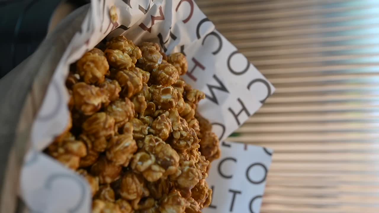 imágenes verticales: un primer plano de las palomitas de maíz recubiertas de caramelo, palomitas dulces
