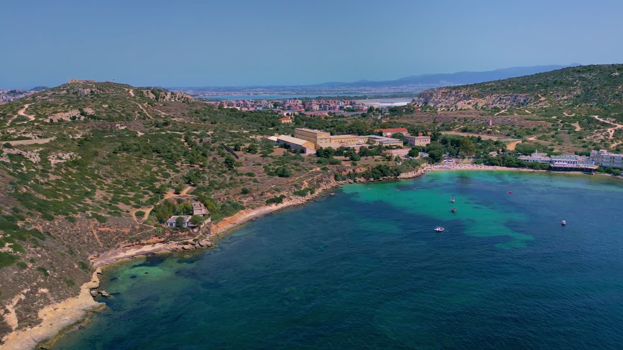 Following the sandy coastline along Spiaggia Calamosca beach, in Sardinia, Italy
