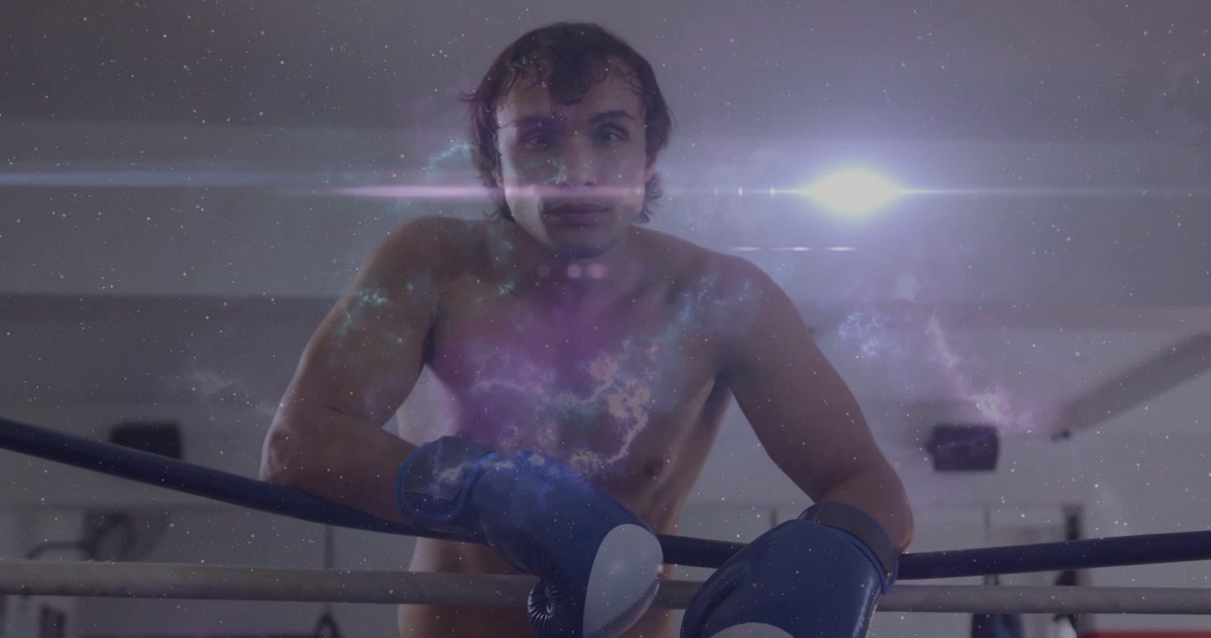 Boxeador masculino sujetando las cuerdas en el gimnasio, con una superposición de nebulosa apareciendo sobre el pecho y un destello sobre los ojos, preparándose.