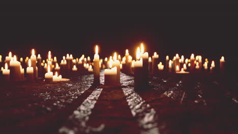 a collection of lit candles on a dark stone surface