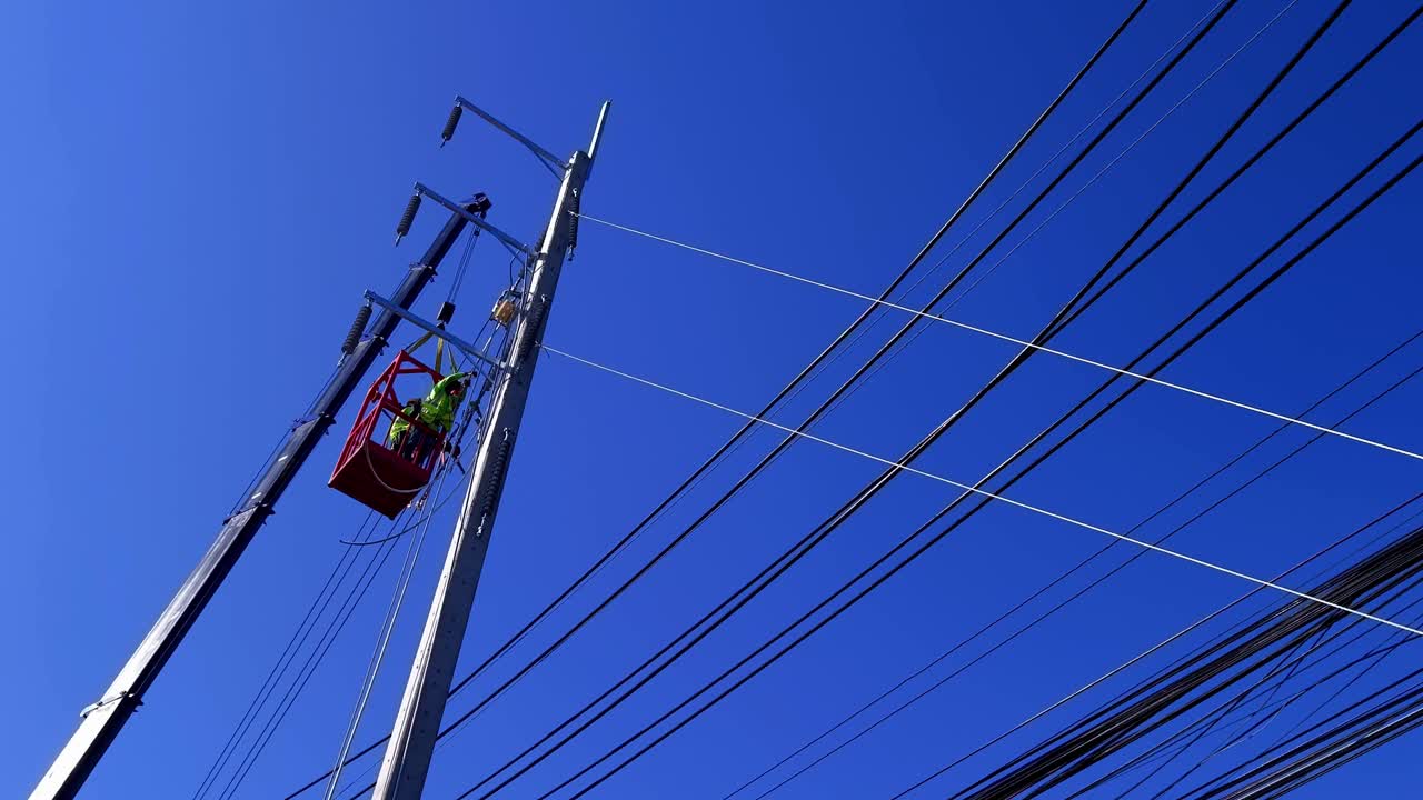 electricista que trabaja en un poste de servicios públicos