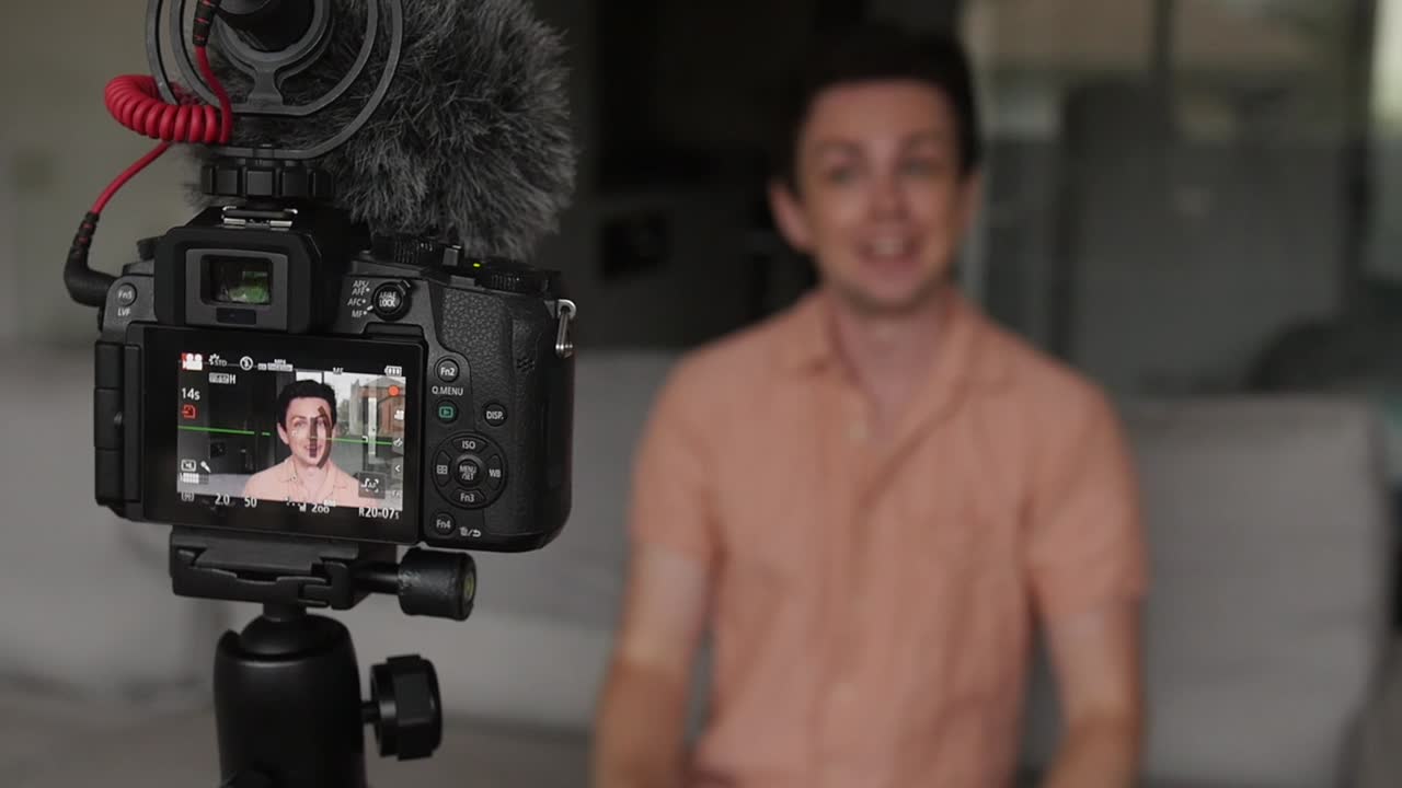 Energetic vlogger talking to camera for social media - focus on camera