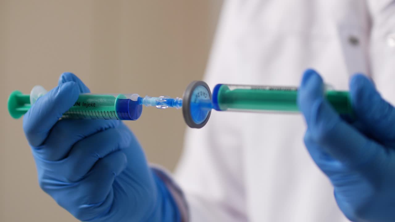 dos jeringas empujan un líquido hacia adelante y hacia atrás