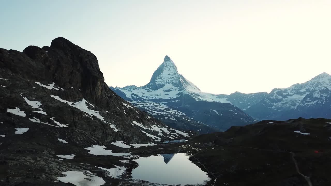 The majestic Matterhorn peak, covered in snow and ice, reflects perfectly in the calm waters of Riffelsee lake in the swiss alps, creating a breathtaking view at dawn Wallis, Switzerland