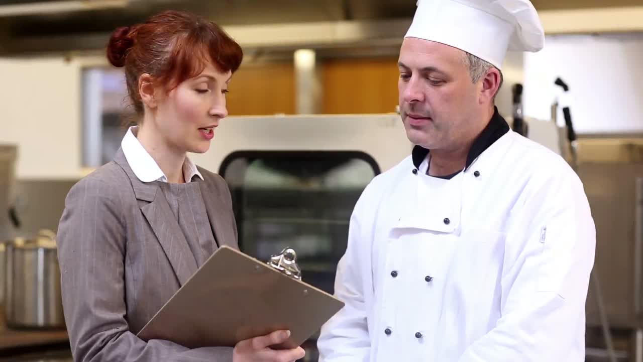 el gerente del restaurante hablando con el jefe de cocina.