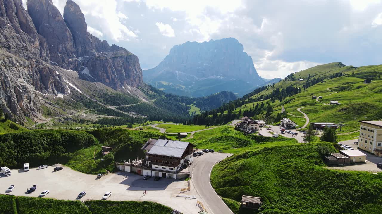 Lush Dolomite valley surrounds mountain road at Ju de Frara under sunny blue sky