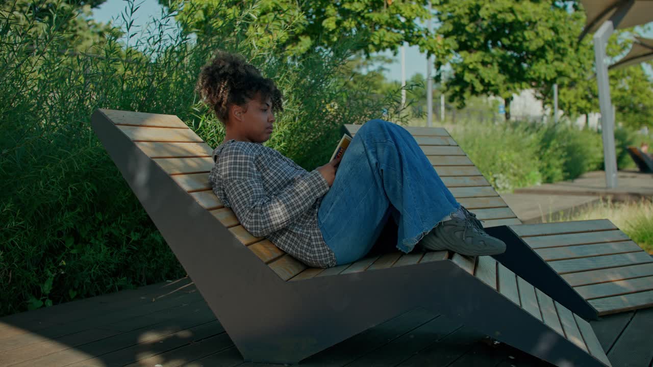 une femme lisant un livre dans un parc
