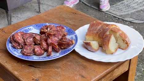 Hausgemachte-Wurst-Und-Selbstgebackenes-Brot-Auf-Dem-Teller,-In-Der-Ländlichen-Landschaft,-Kroatien