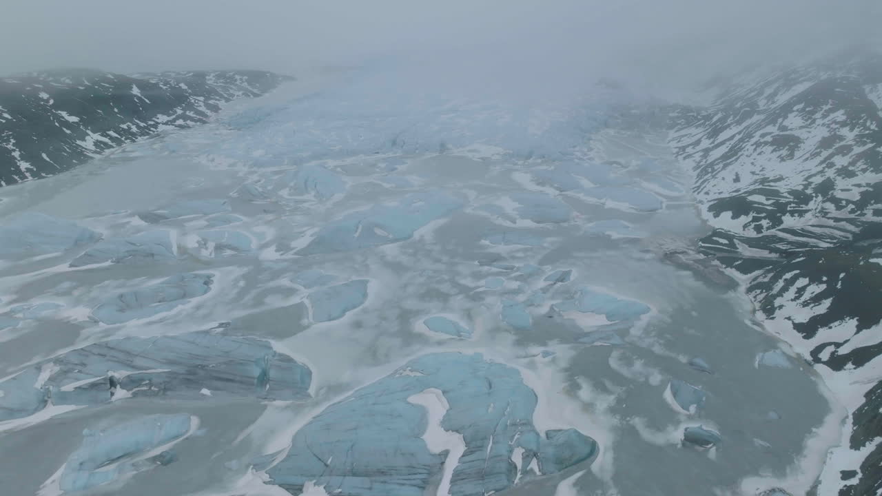 vista aérea del glaciar, el lago glacial congelado y los icebergs en una mañana de primavera brumosa en las tierras altas de islandia