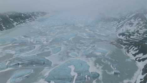 vue aérienne du glacier, du lac glaciaire gelé et des icebergs un matin de printemps brumeux dans les hauts plateaux d'islande