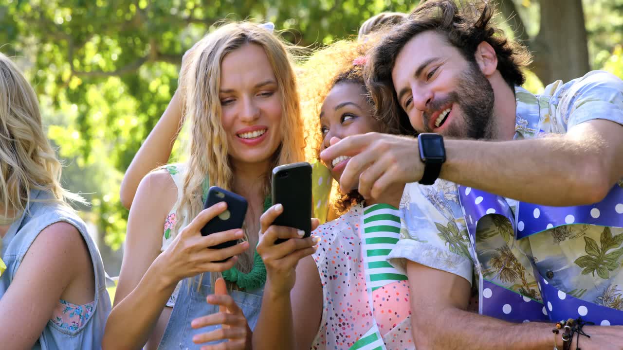 Amici hipster che guardano il loro cellulare e tablet
