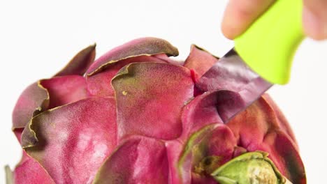 primer plano de cuchillo amarillo cortando fruta de dragón fresca