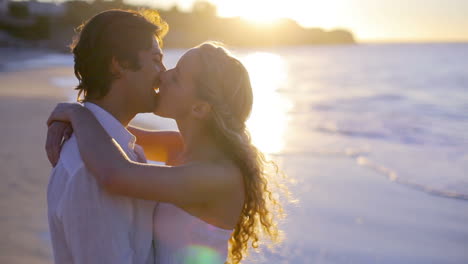 Pareja-Besándose-En-La-Playa-Durante-El-Atardecer