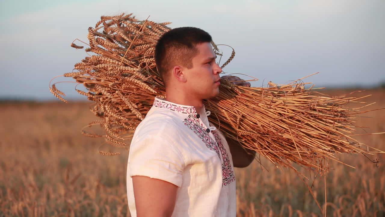 A man takes a sheaf of wheat