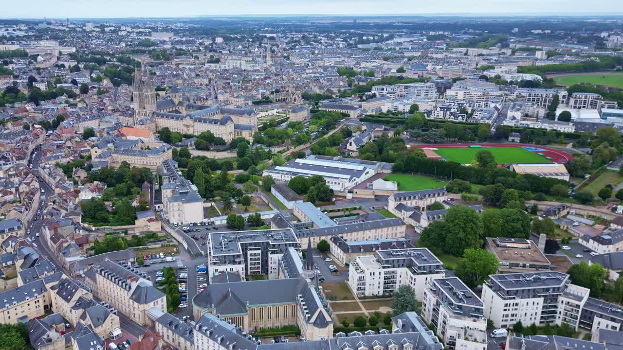 High altitude approaching aerial movement to the abbey of men or L'Abbaye-aux-Hommes, town hall and the prairie racecourse, Caen, France.