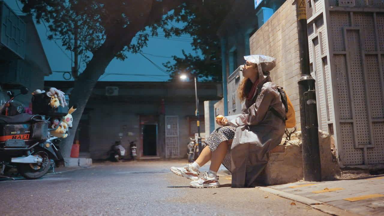 Mujer mayor revisando su teléfono, sonriendo bajo una lámpara de neón mientras toma un descanso nocturno, patinete aparcado cerca, actividad de mercado distante, risa espontánea y pose relajada, ambiente documental con un brillo suave.