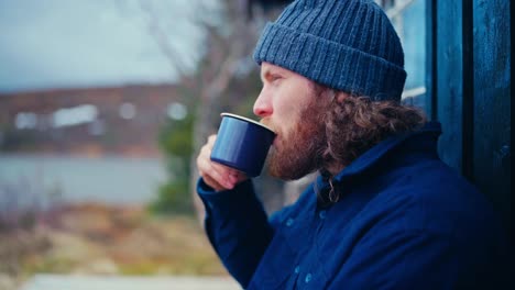 male hiker drinking tea in the morning - close up