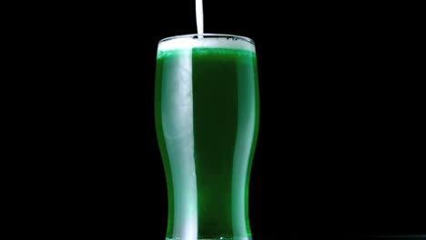 espuma cayendo en una pinta de cerveza verde