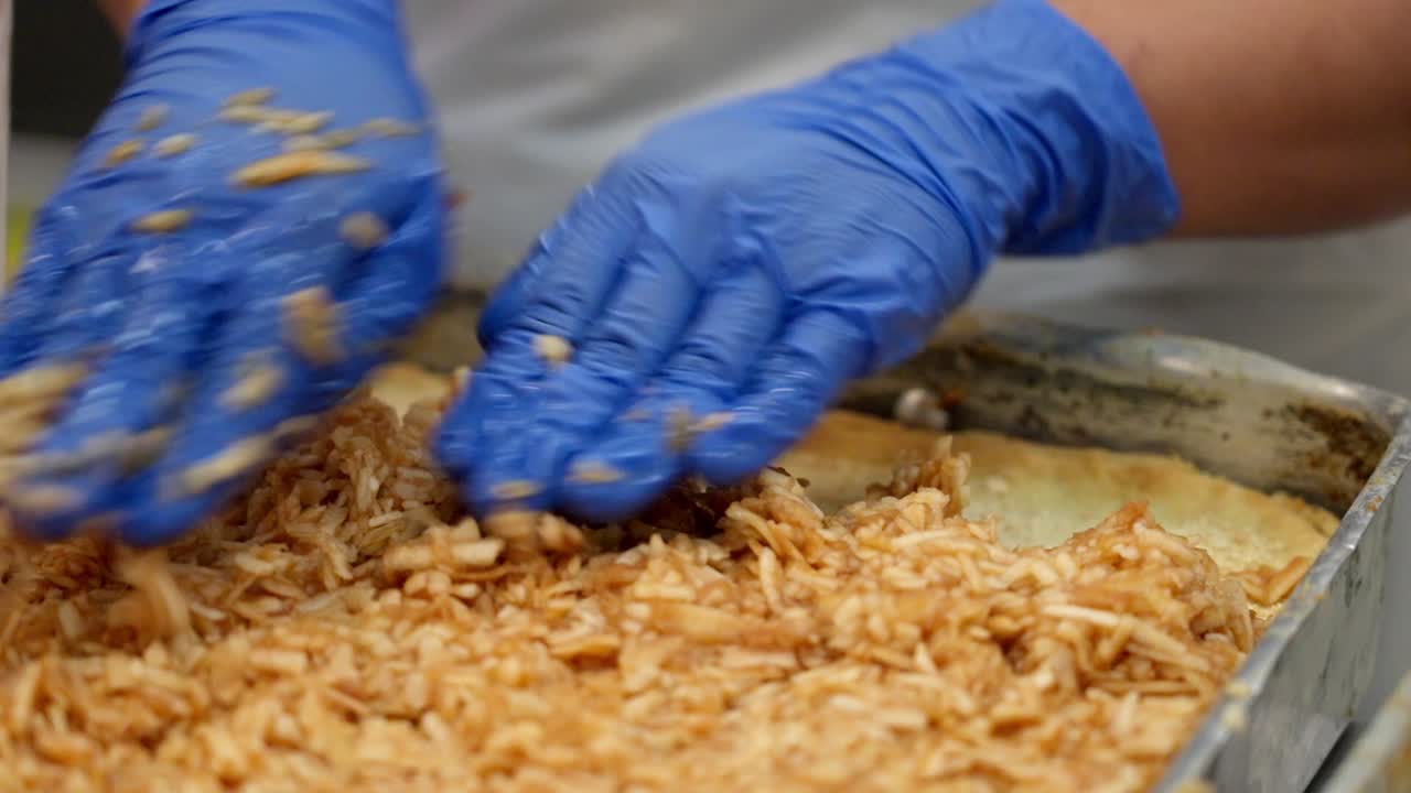 Hands spreading apple filling onto a pastry layer