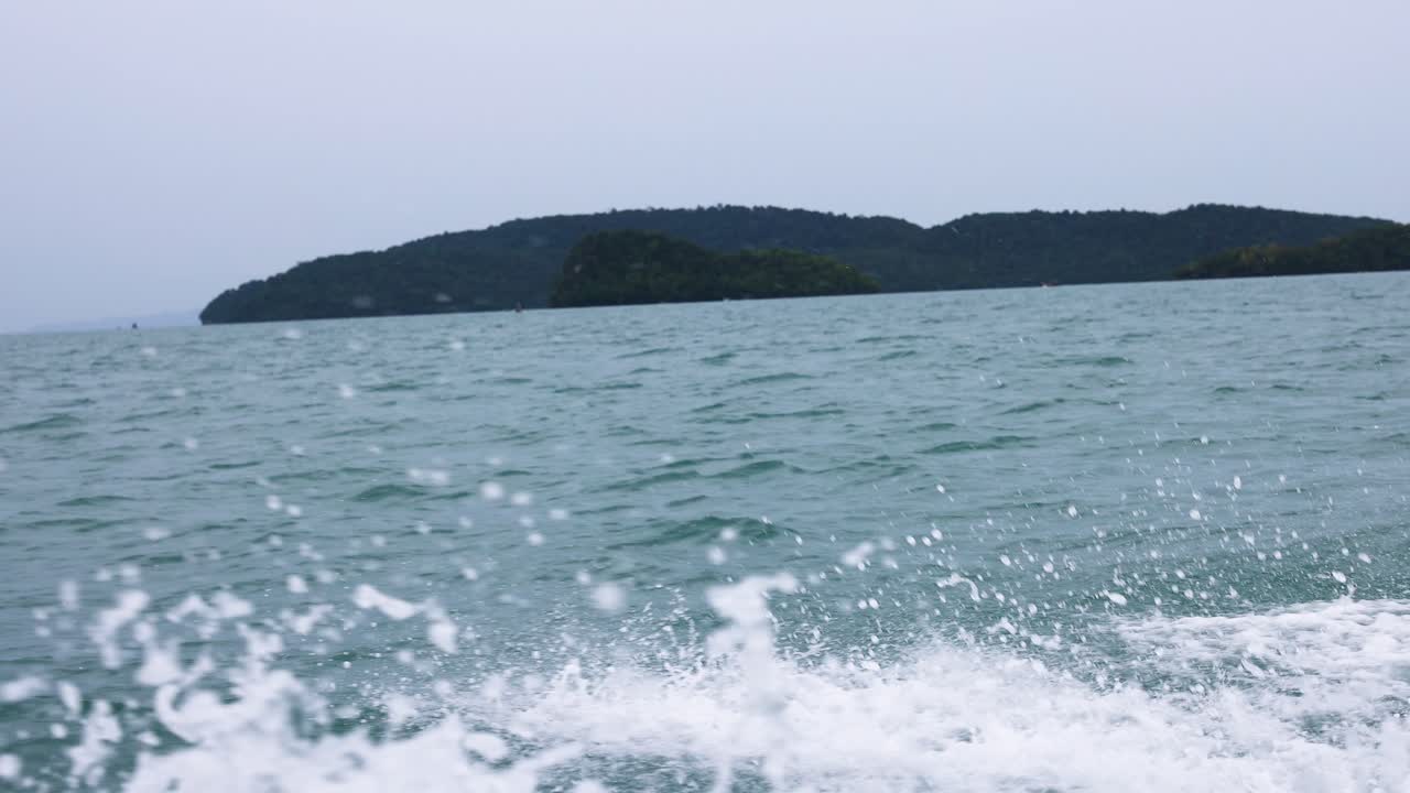 역동적인 바다 파도가 해안에 부히며 태국 크라비의 릴레이 해변의 평온한 아름다움을 포착합니다.