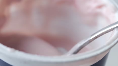 yogur rosa en un recipiente con una cuchara