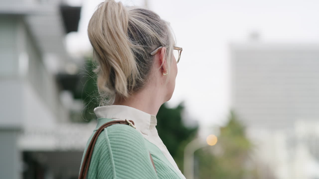 A woman in a cardigan with blonde hair in a ponytail