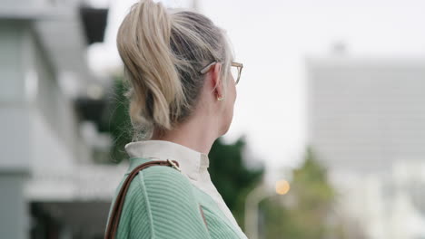 a woman in a cardigan with blonde hair in a ponytail