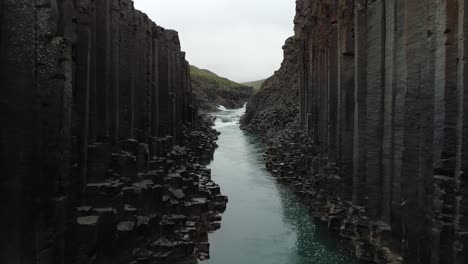 basalt rock columns on banks of a bru river, studlagil canyon, iceland