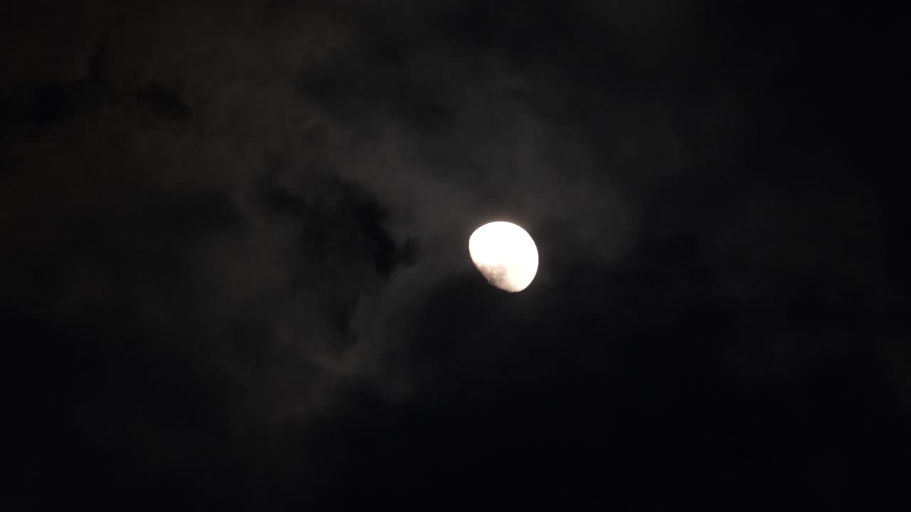 vídeo de luna llena real en una noche oscura y nublada. nubes pasando por la luna, cielo nocturno oscuro,