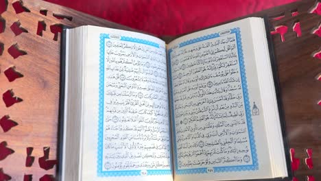 holy quran open on rehal with red prayer rug – 4k islamic spiritual footage