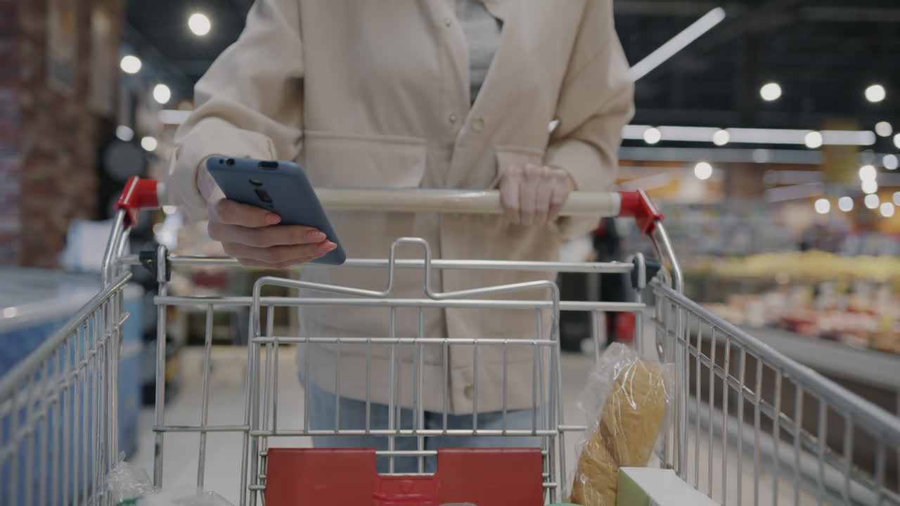 Woman using smartphone in a grocery store