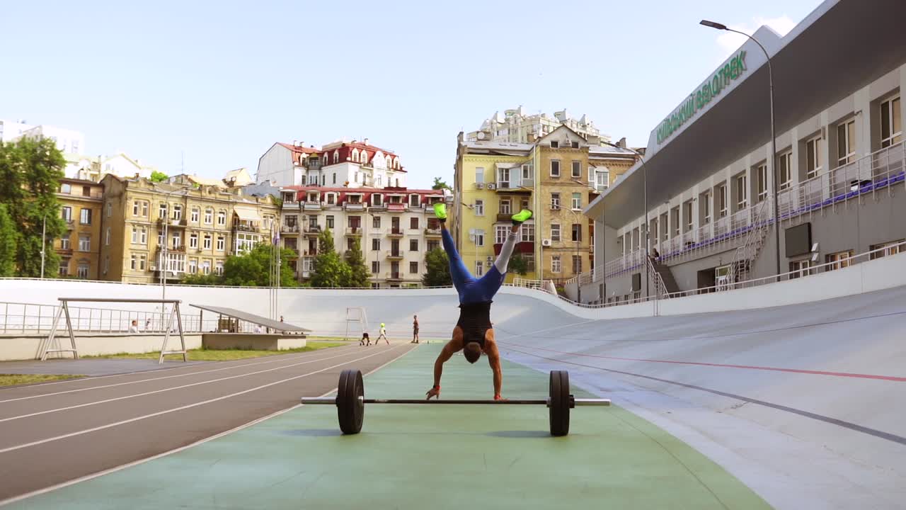 도시 스포츠 단지 에서 바벨 을 들고 손 을 서 있는 남자