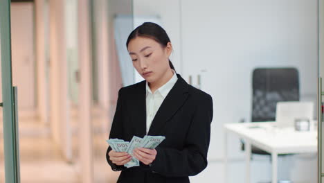 businesswoman holding money in an office