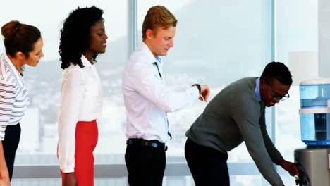 Executives-waiting-in-a-queue-to-drink-water